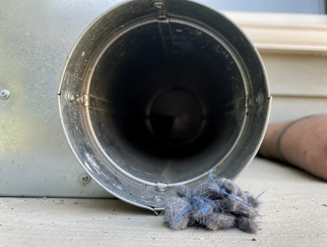 Marblehead Dryer Vent Cleaning technician using specialized equipment to clear severe dryer vent blockage in Marblehead